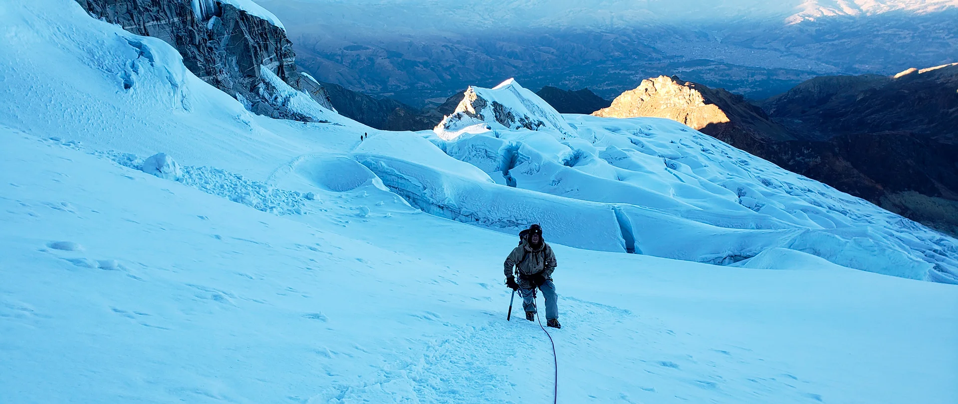 Mountain guide assisting a climber during a mountaineering course on Vallunaraju